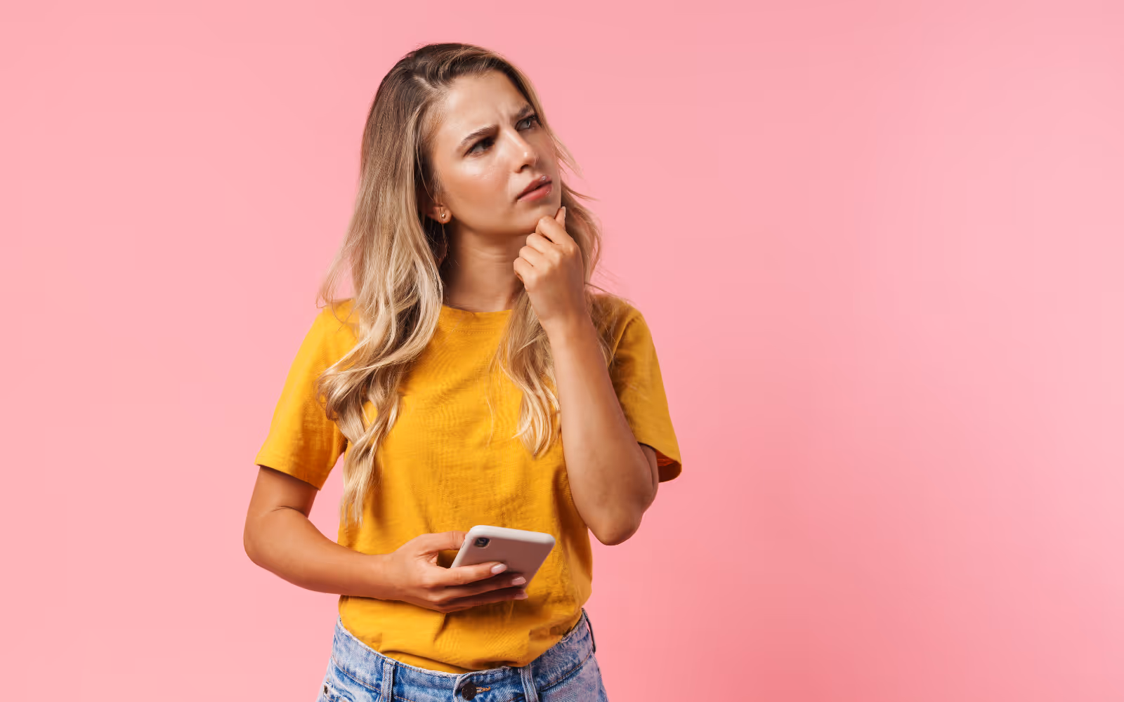Person thinking while holding their phone.
